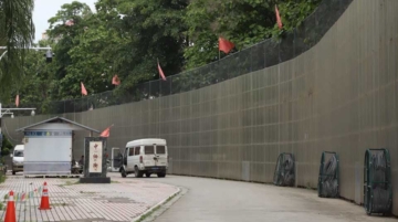 A yellow border wall, about 10 meters high and 170 kilometers long, was erected along the China-Myanmar border in the Jiegao Border Trade Zone in Ruili. This wall, a legacy of the pandemic lockdown, was once described by then-mayor of Ruili, Shang Labian, as a "Great Wall of Steel." (Photo by Fan Shan)