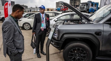 Attendees examine an electric vehicle at an expo during the Second Africa Climate Summit (ACS2) in Addis Ababa, on September 8, 2025. (Photo by Luis TATO / AFP)