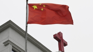 A photo taken on January 15, 2024 shows a Chinese flag fluttering below a cross on a Christian church in Pingtan, in Chinaís southeast Fujian province. A church in east China was scaffolded and its cross removed as a national crackdown on unofficial Christian organisations grows.Photo /GREG BAKER / AFP