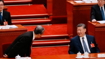 Chinese President Xi Jinping (R) speaks with Chairman of the Standing Committee of the National People's Congress Zhao Leji during a plenary session of China's National People's Congress in Beijing on March 9, 2026. Photo by Vincent Thian / POOL / AFP