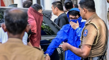 Prison guards escort foreign nationals to a court in Kaduwela, a suburb of Colombo, on May 7, 2026 after their arrest on suspicion of running cyberscam centers. Sri Lanka police arrested 231 foreign nationals, mostly Chinese and Vietnamese, following raids on three suspected cyberscam centres in the capital since the weekend, officials said on May 7. In Sri Lanka, authorities cracked down on two suspected cybserscam centres on May 3, arresting 37 and 120 people respectively. (Photo by Ishara S. KODIKARA / AFP)